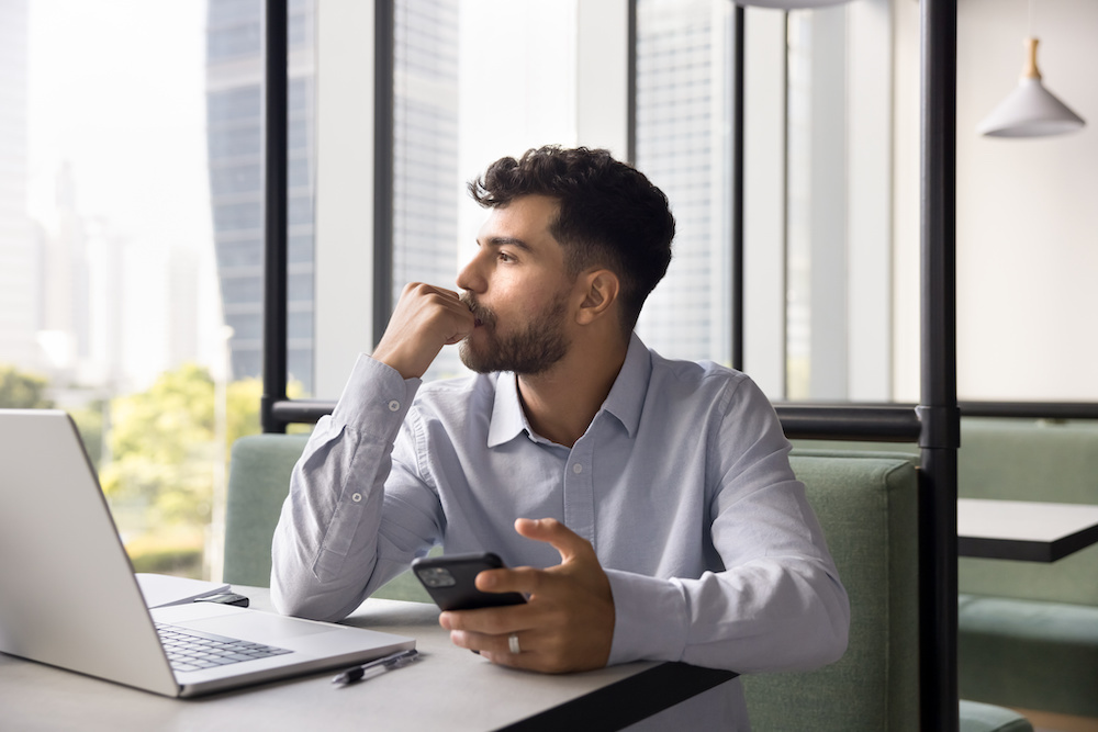 thoughtful-businessman-window-looking-huskimarketing.com